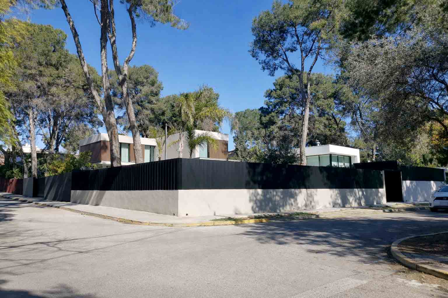 A detached villa in Campolivar set behind walls among umbrella pines and palms, characteristic of the neighbourhood's low-density character.